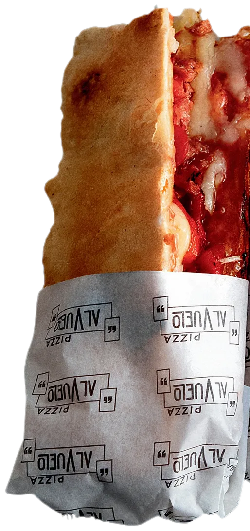 Una pizzetta doblada y envuelta en el papel con el logo de Pizza al Vuelo.