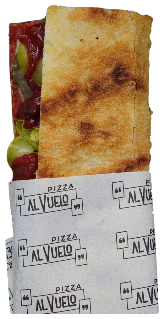 Pizzetta Vegetariana doblada en su papel, con calabacín, pimiento y berenjena a la vista.